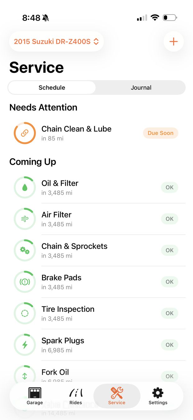 The Service tab for a 2015 Suzuki DR-Z400S. Under Needs Attention, Chain Clean and Lube is due soon, in 85 mi. Under Coming Up, Oil and Filter, Air Filter, Chain and Sprockets, Brake Pads and Tire Inspection are each OK, in 3,485 mi.